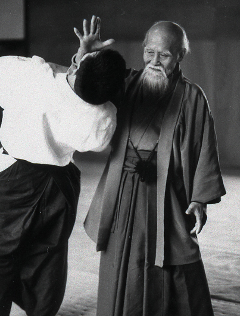 Morihei Ueshiba using very little force to offset his
        partner's center of mass