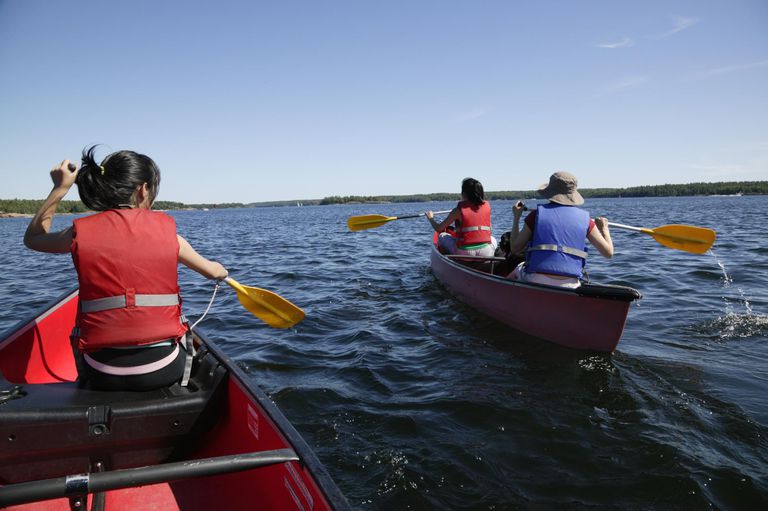 image of people paddling canoes on a lake